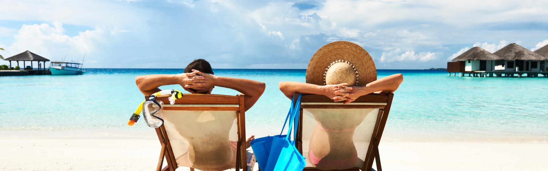 Two people sitting on the beach, enjoying the sun Two people sitting on the beach, enjoying the sun