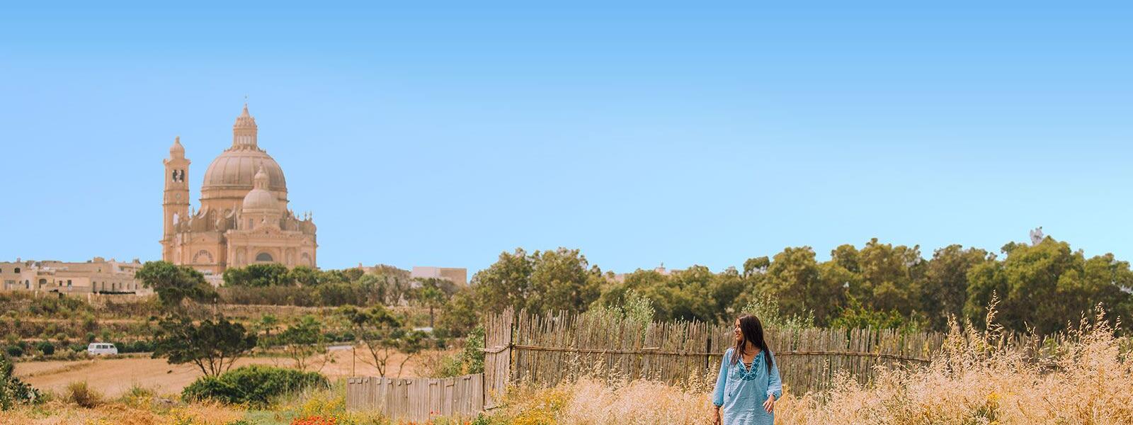 Frau auf den Feldern vor der Basilika ta’ Pinu auf Gozo